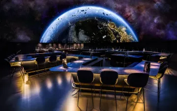 Interior of a futuristic restaurant with a panoramic view of Earth from space, illustrating the concept of dining in zero gravity