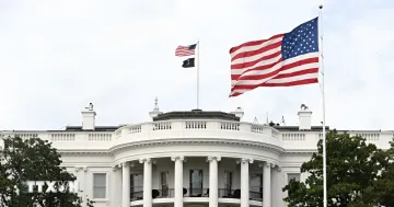 Белый дом в Вашингтоне с развевающимися флагами США и штата, символизирующий центр политической борьбы: 25 штатов подали иск против администрации Трампа из-за тарифной войны