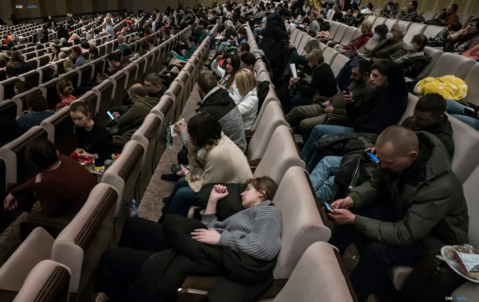 Украинские беженцы в зале временного размещения, мужчины призывного возраста на фоне новостей о новых правилах ЕС