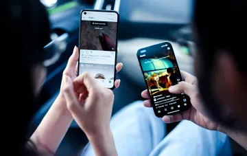 Две руки держат смартфоны с открытым Instagram, иллюстрируя потерю экосистемы Apple при переходе на Android в 2026 году