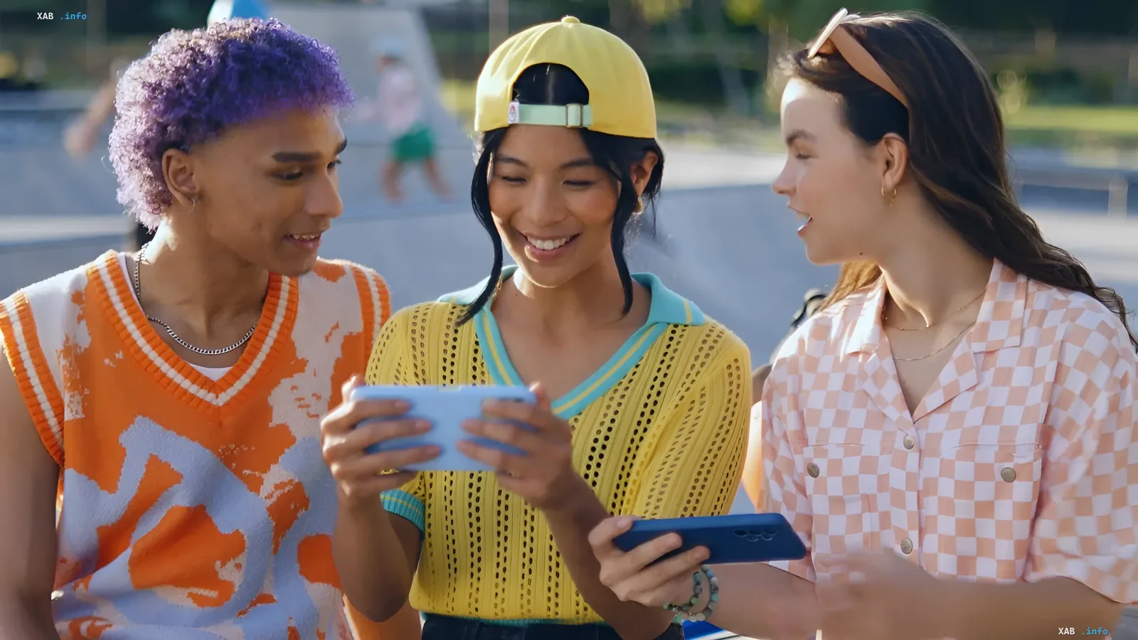 Drei Freunde schauen auf ein Smartphone mit dem Spiel Pokémon Champions und diskutieren neue Boni für Trainer