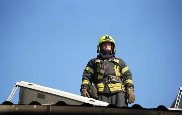 Rescuer in protective gear on the roof of a building after a missile strike on the suburbs of Odesa