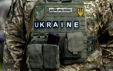 Ukrainischer Soldat mit 'Ukraine'-Aufnäher und ZSU-Emblem, das die wachsende Anzahl von Stellen in der Armee illustriert