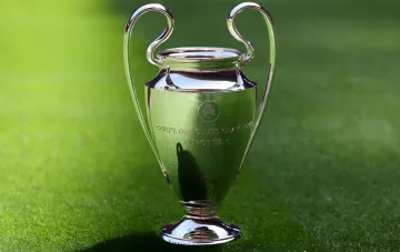 UEFA Champions League Pokal auf einem grünen Rasen, der den Start der Qualifikationsrunde und den Spielplan des dritten Runds symbolisiert