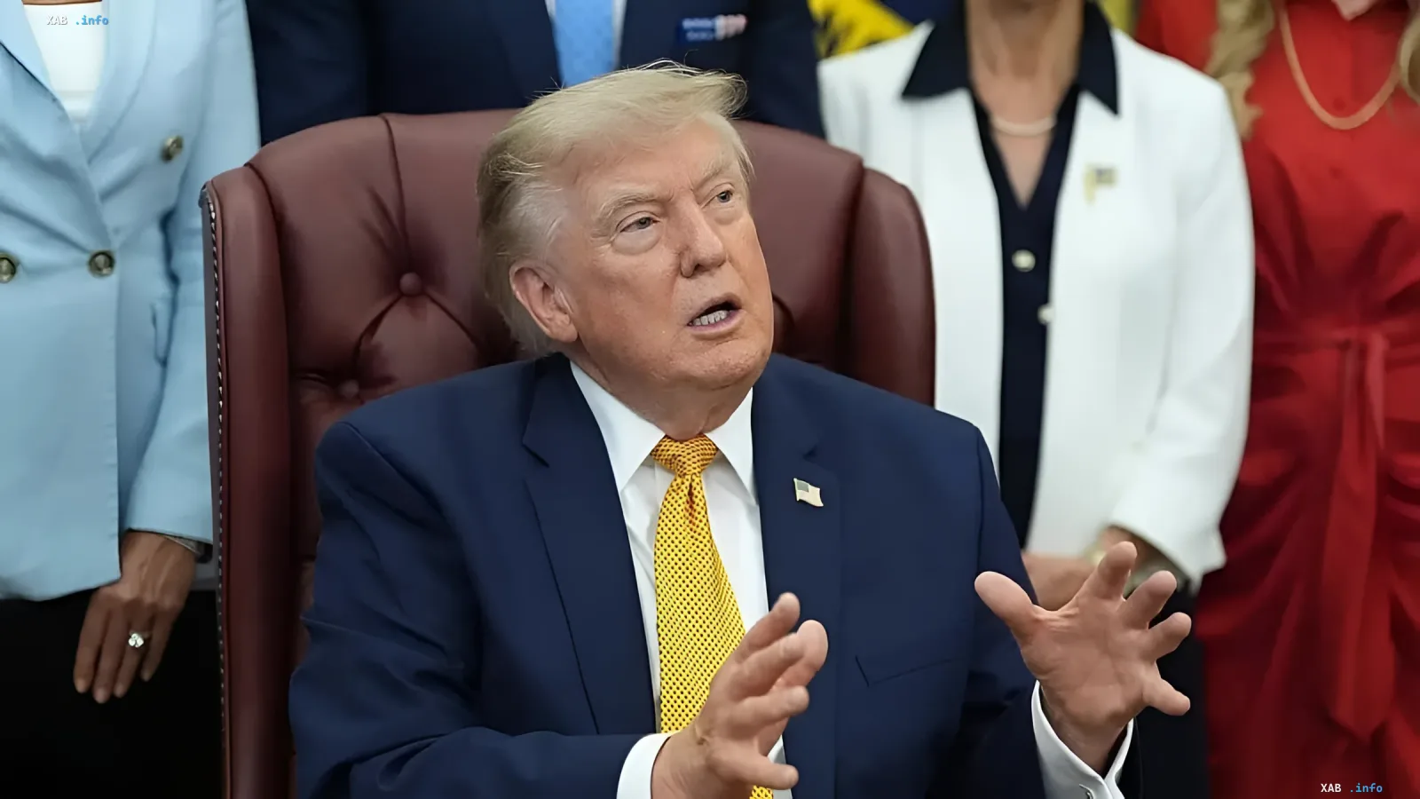 Дональд Трамп в синем костюме и желтом галстуке жестикулирует во время выступления, на фоне — официальные лица; иллюстрирует тему переговоров США и Ирана