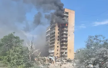 Последствия авиабомбардировки в Краматорске: горящее здание с густым черным дымом и разрушениями