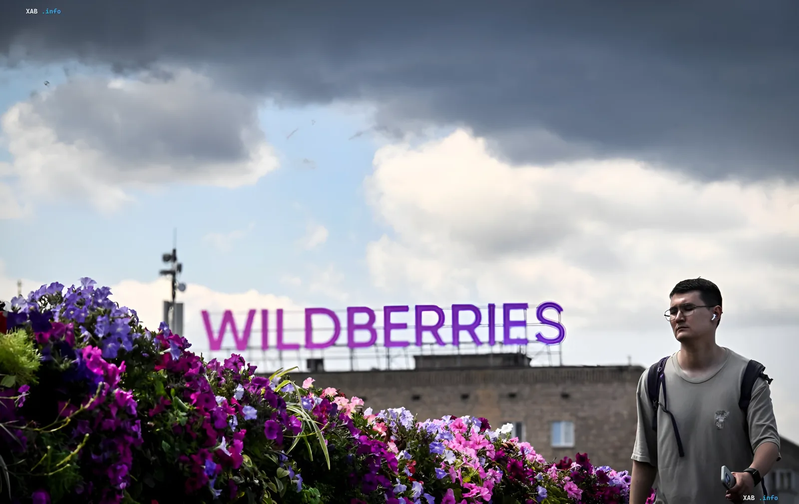 Логотип Wildberries на фоне грозового неба с беспилотниками в воздухе, символизирующий атаку на логистику компании