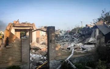 Зруйнований будинок у Сумах чи Миколаєві після удару: уламки стін, цегли та даху, дим на тлі чистого неба — наслідки атаки, що забрала життя дітей та літніх людей