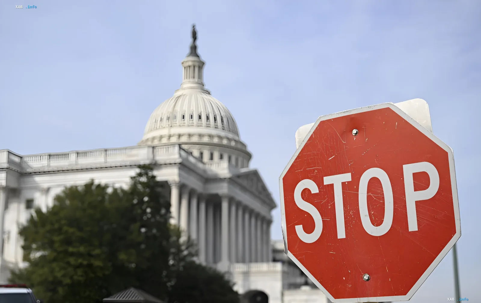 Stop sign in foreground with blurred U.S. Capitol building in background — metaphor for halting legislative changes in Ukraine