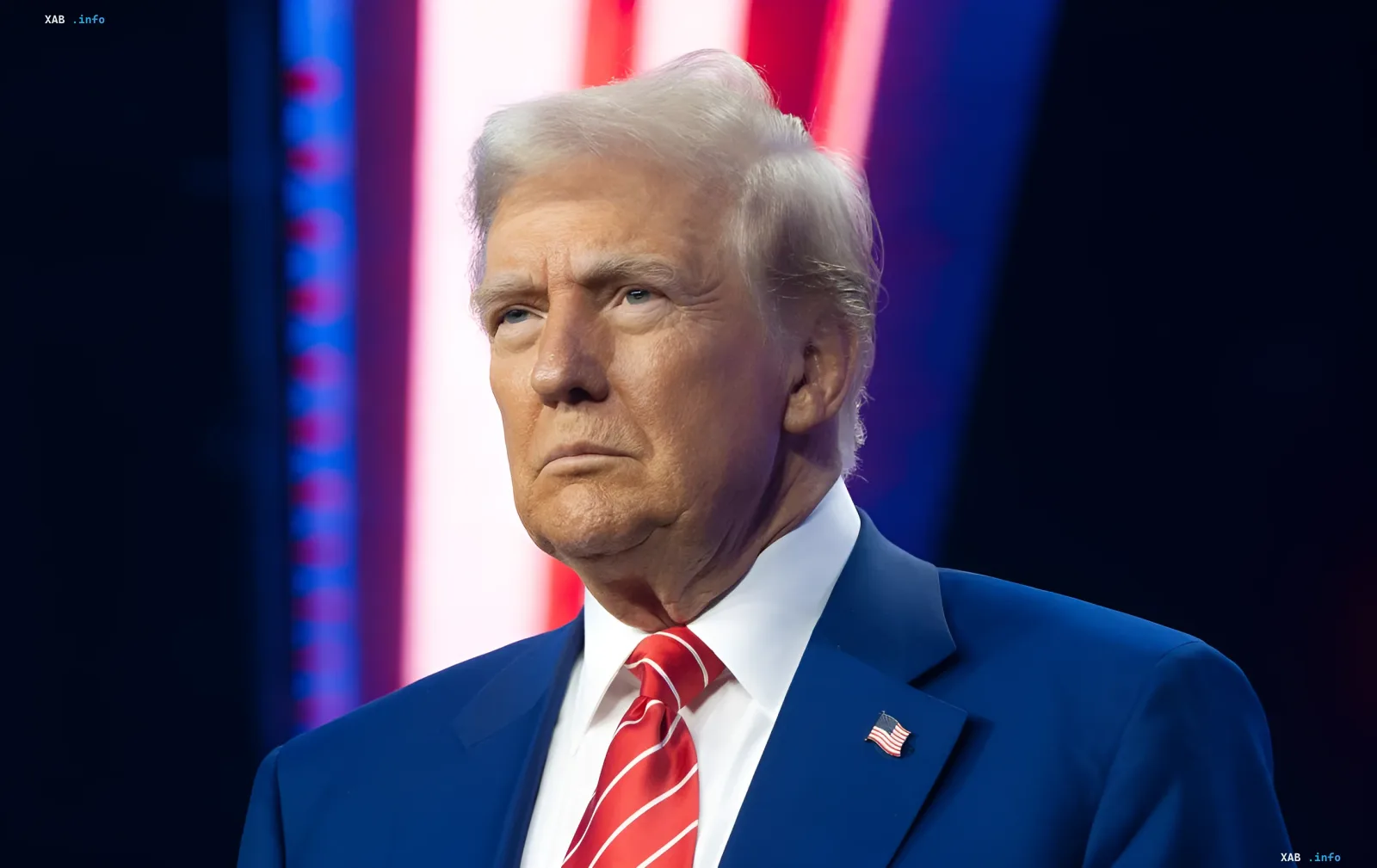 Дональд Трамп у синьому костюмі з американським прапором на лацкані, на тлі червоно-синіх світлових смуг — ілюстрація до новини про його заяву щодо підготовки атаки на Іран з часів Другої світової війни