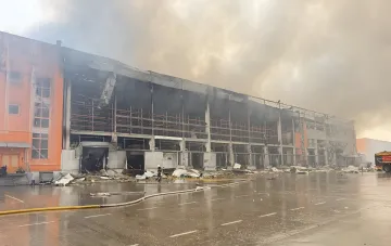 Aftermath of drone attack on LIQUI MOLY central warehouse in Ukraine: destroyed building and firefighters at work