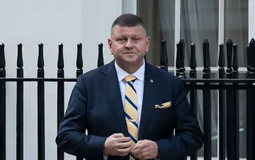 Генерал Валерий Залужный в деловом костюме с украинским триколором на галстуке, символизирующим позицию Украины по НАТО