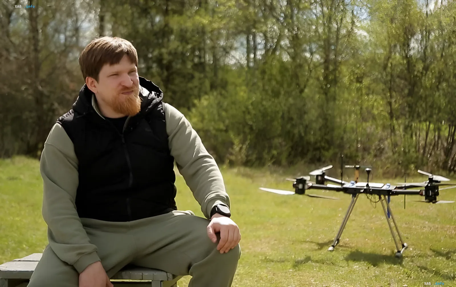 Wladimir Tkatschuk, Geschäftsführer von 'Uraldronzavod' und Militär-Blogger, sitzt auf einer Bank neben einem Drohne vor einem Hintergrund aus grüner Natur