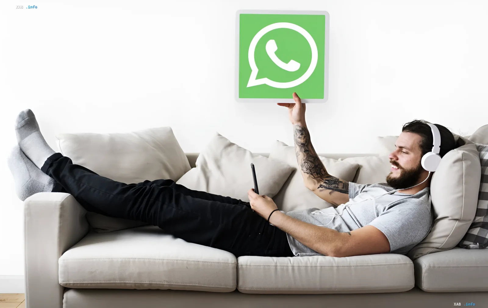 Person on a couch with a phone and WhatsApp logo, showcasing new group features