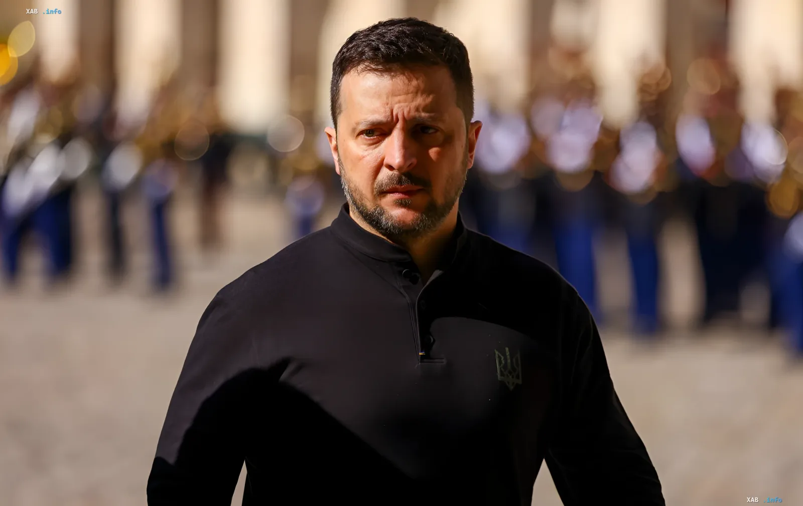 Президент України Володимир Зеленський у чорній сорочці з емблемою тризуба на фоні розмитого строю військовослужбовців — символ затвердження нової дати Дня військ зв'язку та кібербезпеки