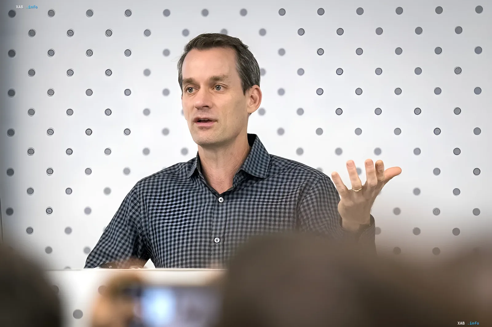 Jeff Dean, a Google veteran, delivers a presentation against a tech-inspired backdrop, discussing the future of AI