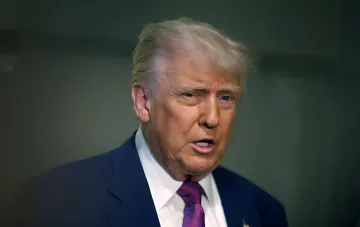 Donald Trump im blauen Anzug und roten Krawatte, vor dunklem Innenraum-Hintergrund — Bild im Zusammenhang mit dem Marine-One-Vorfall