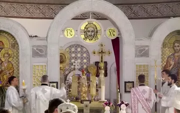 Gottesdienst in der Kirche der UOC zur Verklärung des Herrn und Apfelfest: Priester in weißen Gewändern am Altar mit Christusikone
