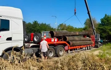 Монтаж водопроводных труб в Марганце: кран грузит трубы на грузовик для восстановления водоснабжения