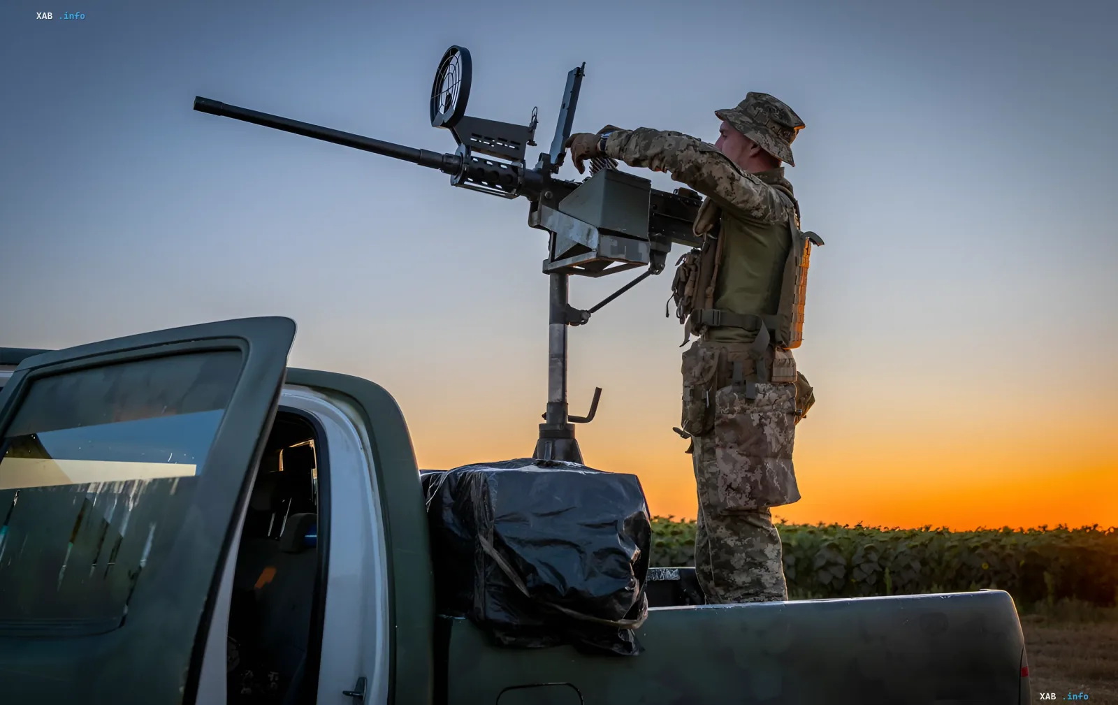 Ukrainischer Soldat am Maschinengewehr auf Pickup-Truck bei Sonnenuntergang — Symbol der ukrainischen Verteidigung während des massiven russischen Angriffs am 6. August