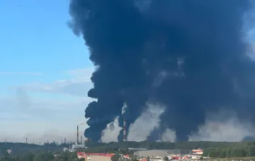 Dicker schwarzer Rauch steigt in den Himmel über einem Industriegebiet mit sichtbaren Rohren einer Ölraffinerie nach einem SBU-Anschlag auf eine strategische Anlage in Jaroslawl.