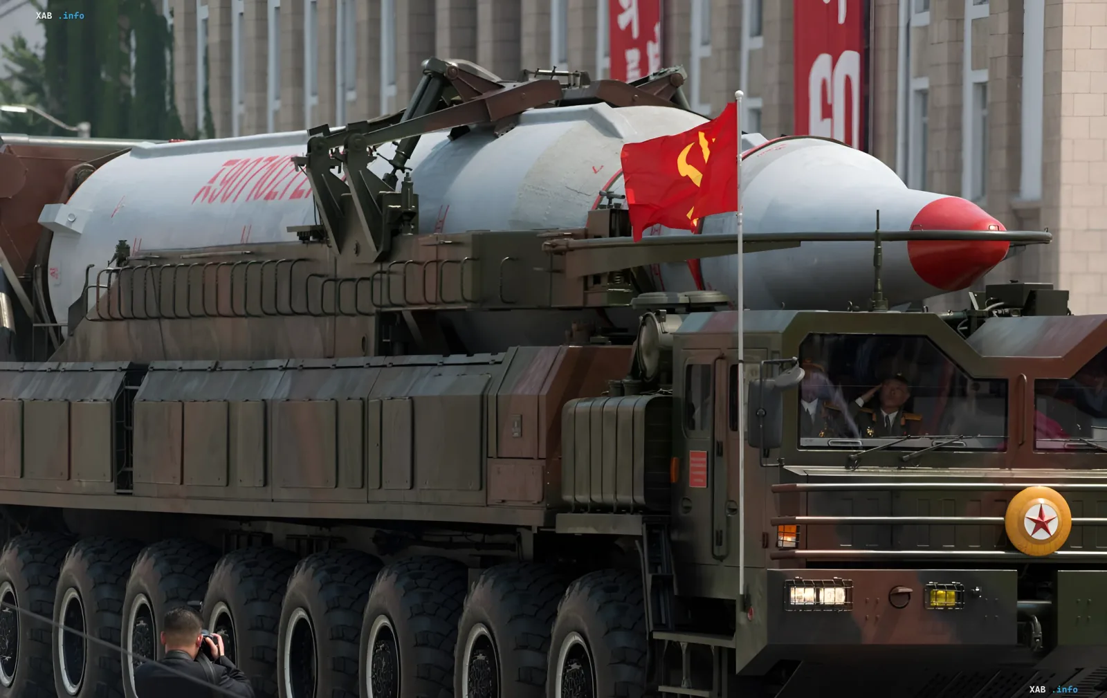 North Korean missile system on parade: ballistic missile on wheeled launcher with North Korean flag