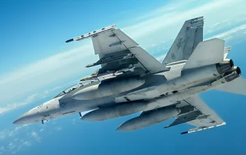 Истребитель F/A-18 Hornet ВМС США в полете с боевой нагрузкой, включая ракеты AIM-9 Sidewinder, символизирующий усиление военной помощи Украине и запуск серийного производства бомб JDAM LR