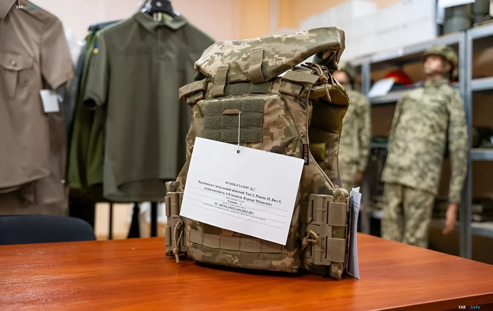 Schutzweste bei Tests in der Ukraine: Probe mit Etikett auf Tisch, Militäruniformen und Mannequins im Hintergrund