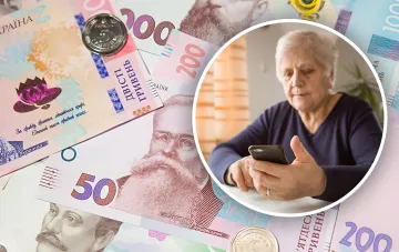 Rentnerin mit einem Handy vor dem Hintergrund von ukrainischen Griwna und einer Rentenbescheinigung, was die Notwendigkeit symbolisiert, einen Antrag auf eine Beihilfe für Brennholz und Kohle im Jahr 2026 zu stellen