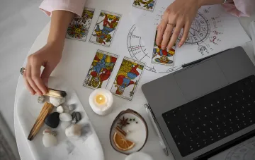 Tarot-Kartenleger auf einem Tisch mit Horoskop, Kerze und Steinen — Symbol der Vorhersage für den 6. August