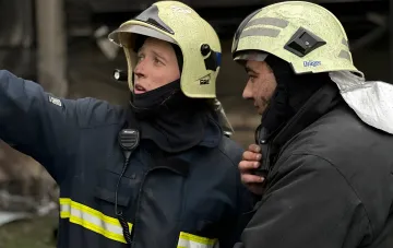 Rettungskräfte in Schutzkleidung am Ort eines russischen Drohnenangriffs auf den Bahnhof in Lozowa