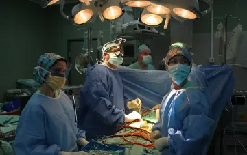 Surgical team performing a complex heart transplant surgery on a child in an operating room