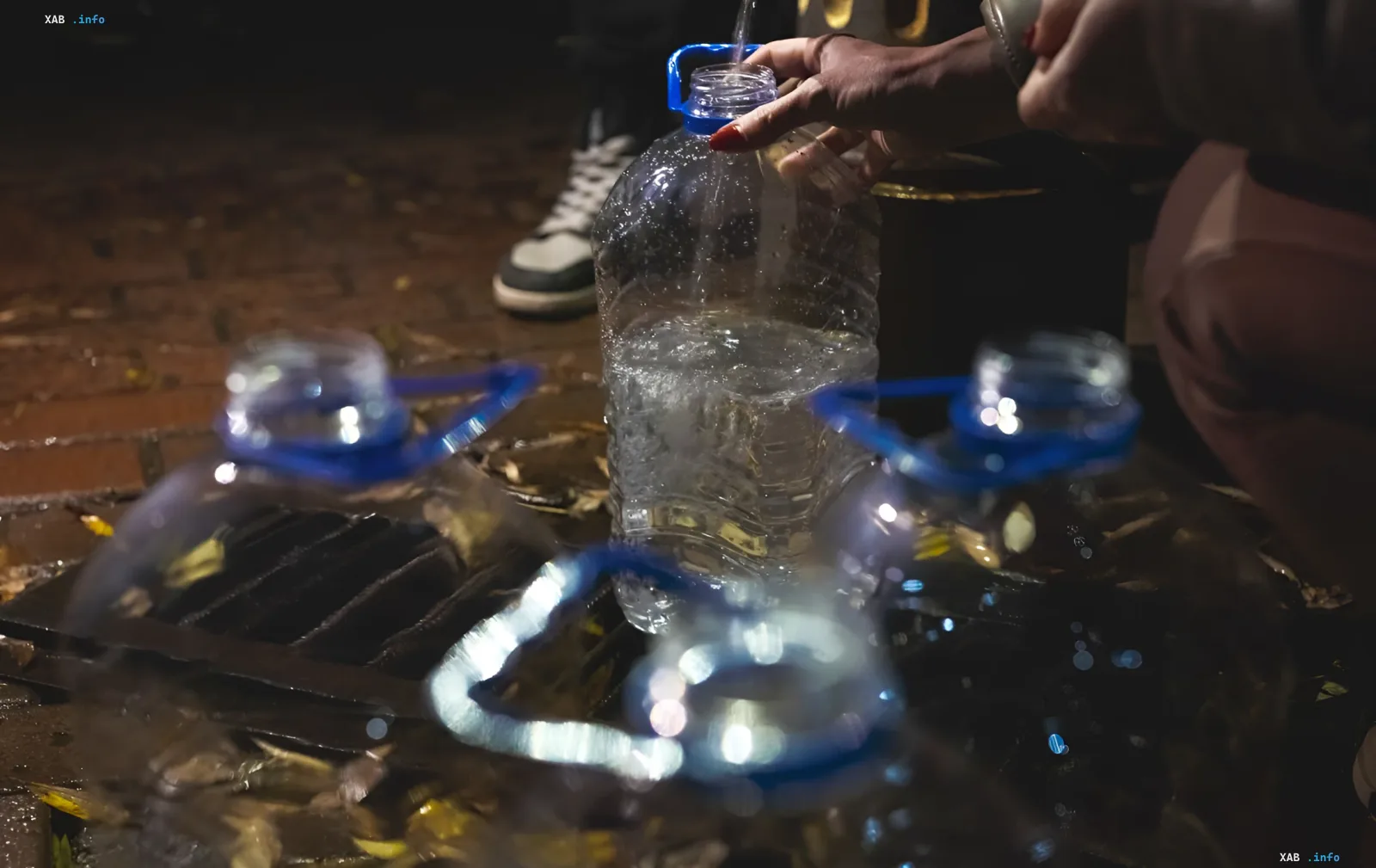 Resident of Marganets fills plastic bottles with water during the water crisis