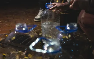 Resident of Marganets fills plastic bottles with water during the water crisis