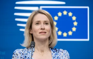 Кая Каллас на пресс-конференции перед флагом ЕС, обсуждая новые санкции против России
