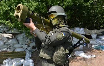 Ukrainian soldier with ATGM ready to repel an attack against a backdrop of sandbags