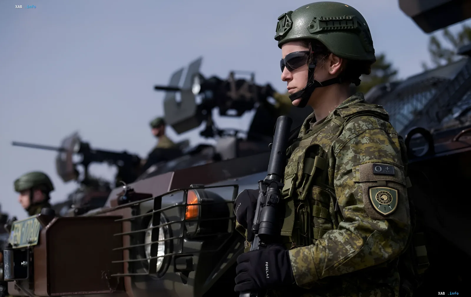 Ukrainische Soldatin in Tarnuniform und Helm steht neben einem gepanzerten Fahrzeug und symbolisiert die umfassende militärische Unterstützung der NATO für die Ukraine in den Jahren 2026–2027