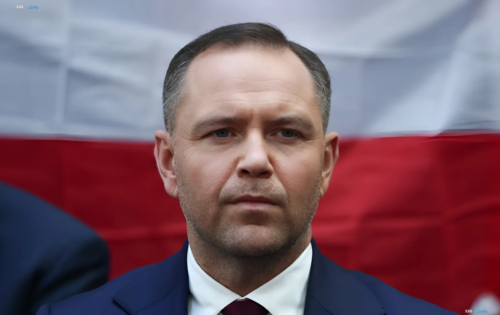 Кароль Навроцкий, министр обороны Польши, на фоне польского флага, обсуждает условия военной помощи