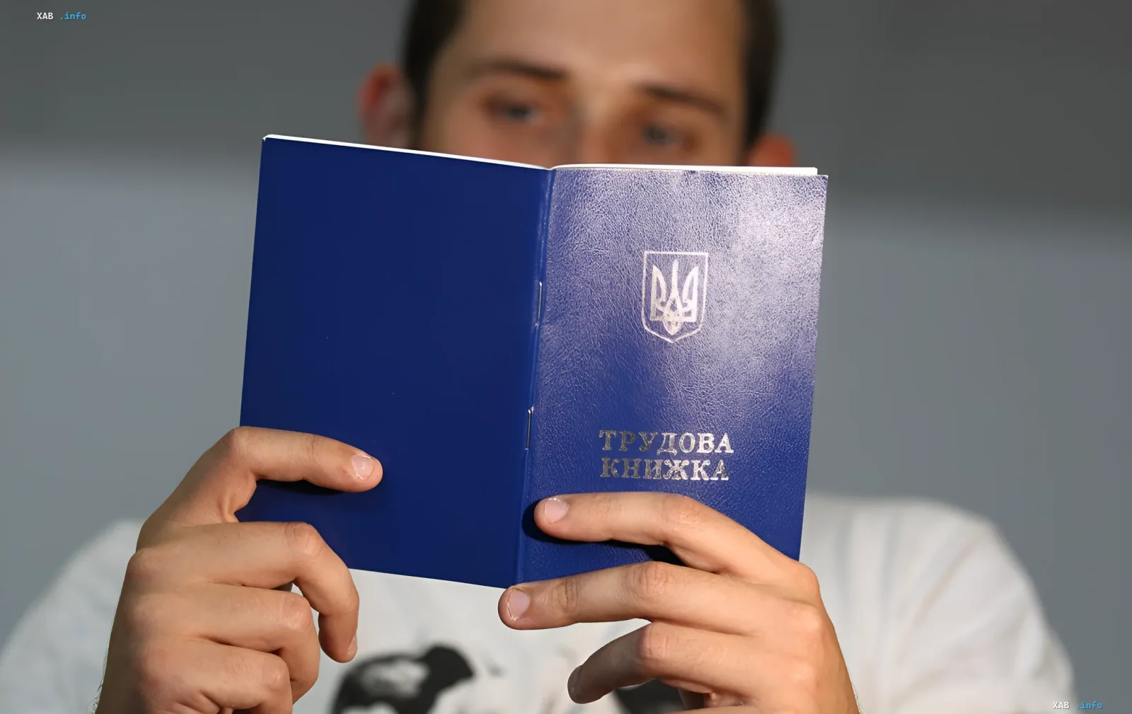 Человек держит открытую трудовую книжку Украины, символизируя поиск потерянного стажа для пенсии