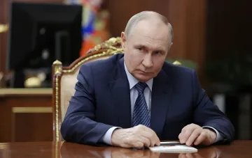 Владимир Путин за рабочим столом, размышляющий о новой стратегии безопасности и изменении маршрутов поездок