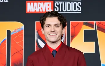 Том Холланд на премьере фильма Marvel Studios, улыбающийся в красном костюме