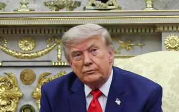 Дональд Трамп в синем костюме и красном галстуке, сидящий в роскошном интерьере, опровергает поддержку Вэнса на выборах 2028 года