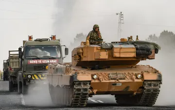 Турецкий танк M60T в колонне военной техники на фоне задымленного неба — символ укрепления оборонного альянса Турции, Саудовской Аравии и Пакистана