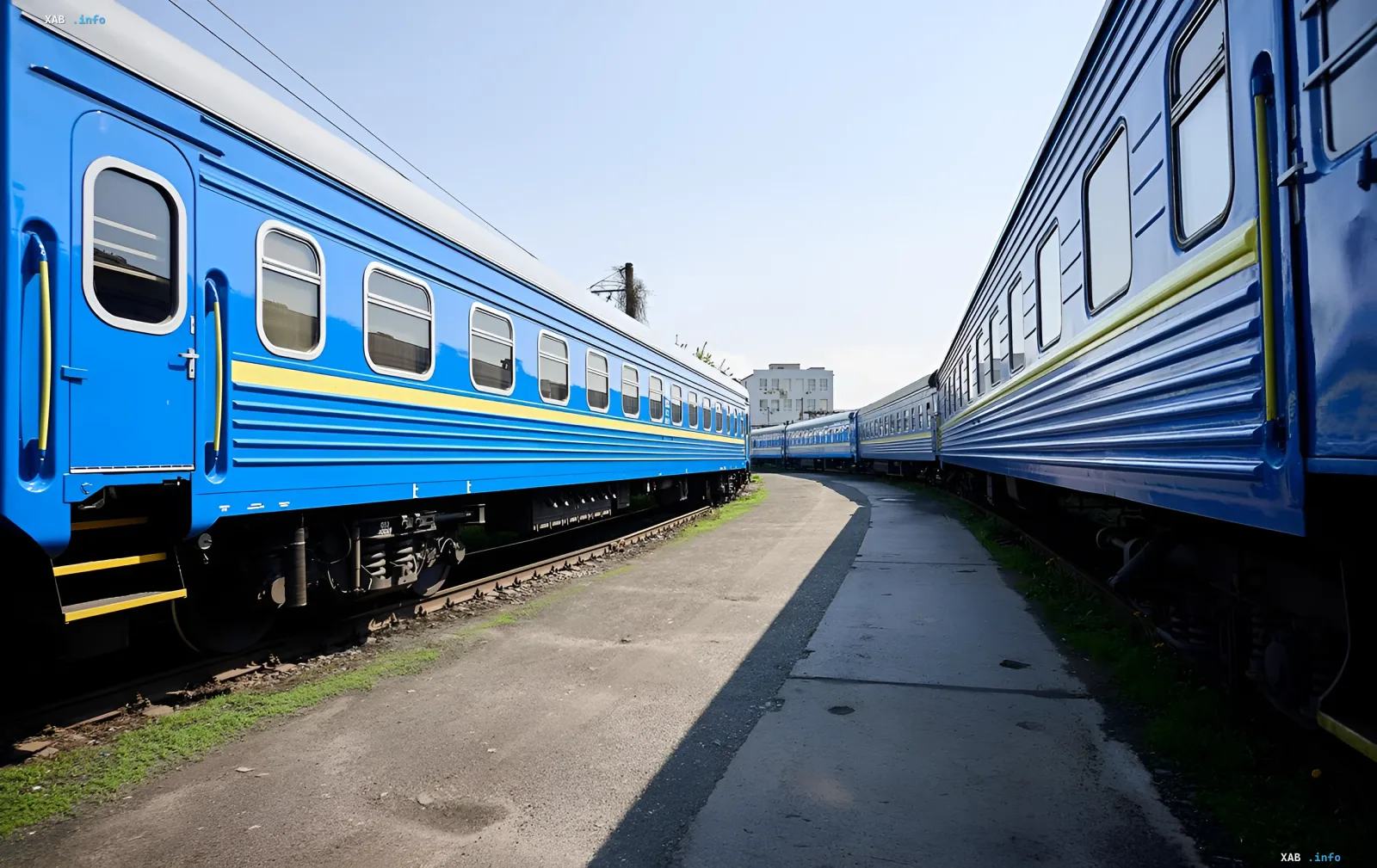 Blue passenger carriages of Ukrzaliznytsia at a railway station, illustrating route changes due to shelling