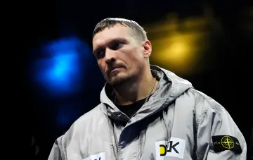 Александр Усик в серой куртке с логотипом Stone Island, задумчивый взгляд перед боем с Уайлдером