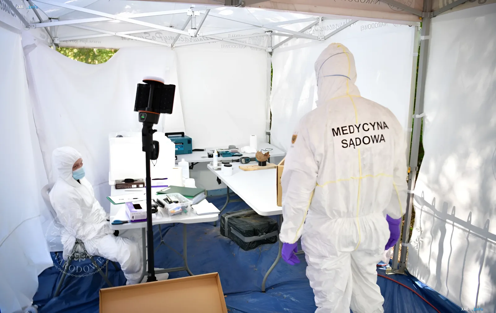 Forensic medicine specialists in protective suits work in a tent during the exhumation of victims of the Volhynian tragedy of 1943