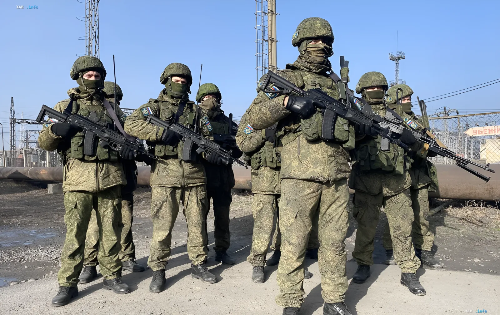 Российские военные в камуфляжной форме с автоматами на фоне промышленной зоны, символизирующие присутствие РФ в Южной Осетии к 18-летию войны в Грузии