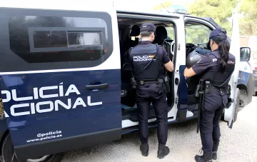 Испанские полицейские Национальной полиции (Policía Nacional) у служебного фургона после ликвидации сети контрабанды наркотиков и мигрантов на 24 млн евро