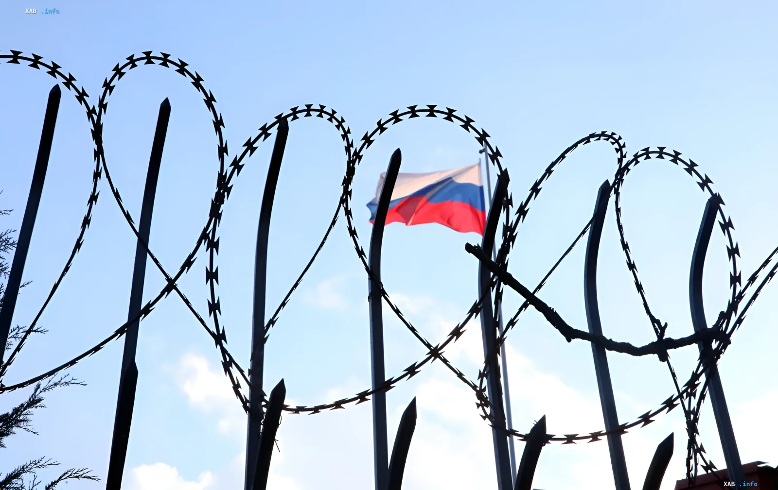 Stacheldraht vor dem Hintergrund der russischen Flagge, die Sanktionen und Einschränkungen symbolisiert