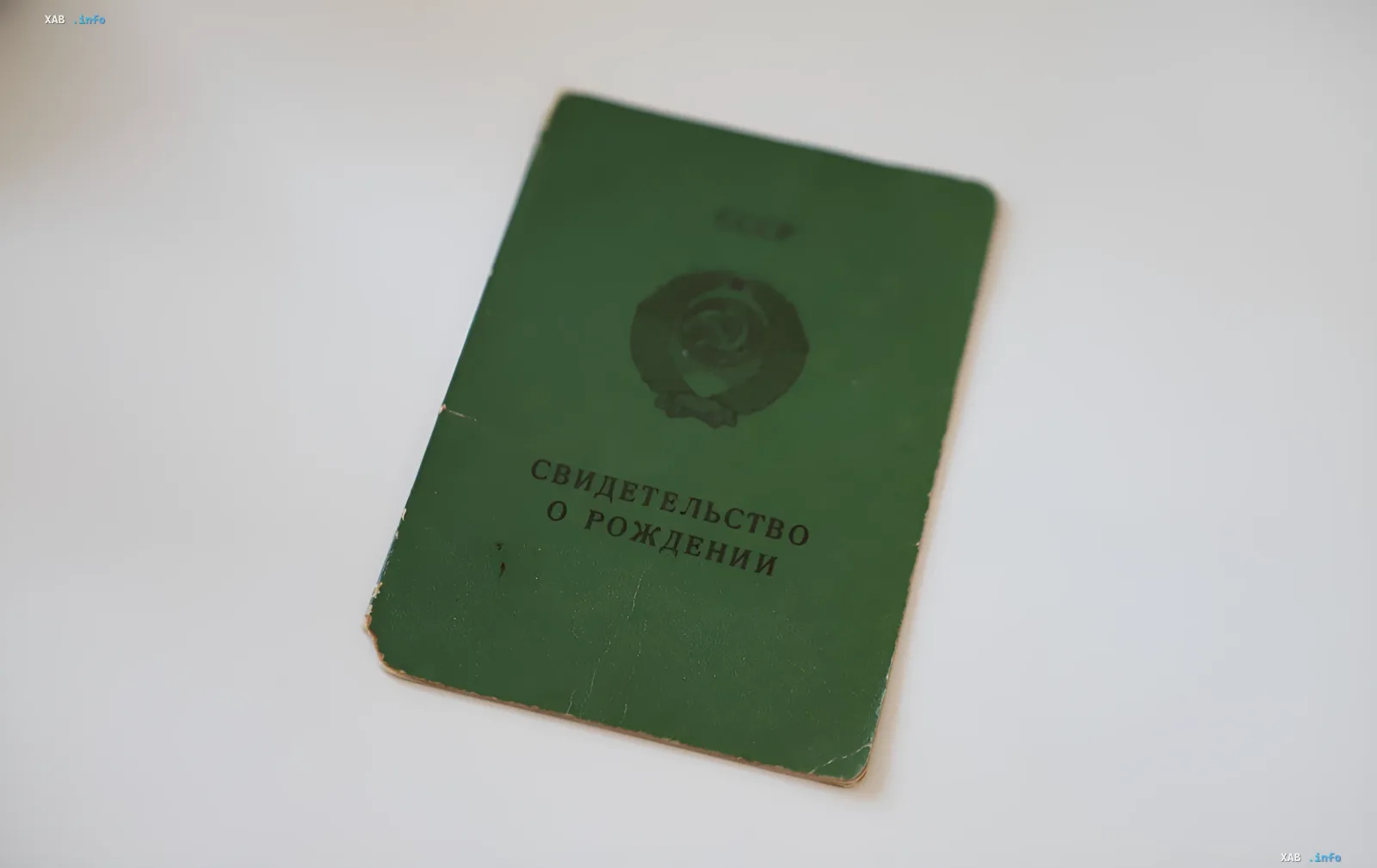 Зеленое советское свидетельство о рождении СССР с гербом, лежащее на белом фоне — актуально для статьи о замене документов в 2026 году